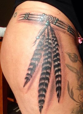 Tatouage plume style ceinture indienne sur la hanche